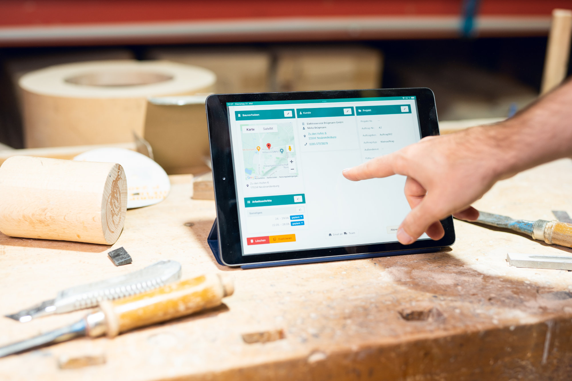 Tablet mit Artesa-App auf einer Werkbank bei Treppenbau Plath, Projekt- und Bauvorhaben-Daten direkt am Arbeitsplatz